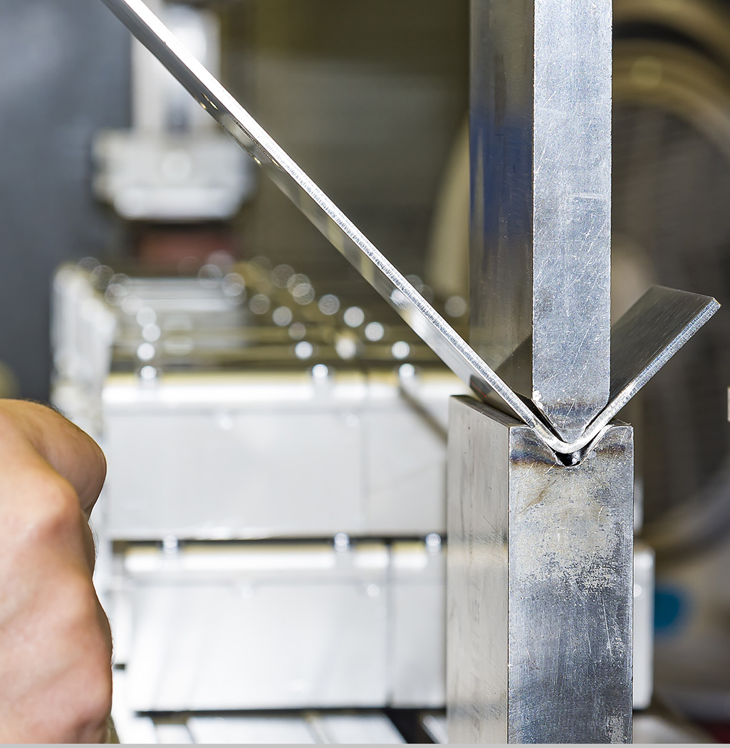 worker operating metal press machine at workshop.